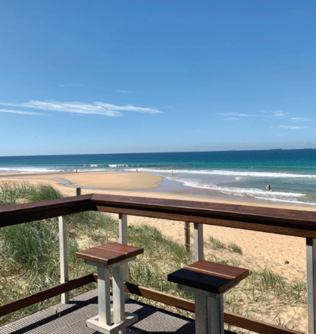 Image of bar and bar stools overlooking the ocean. 