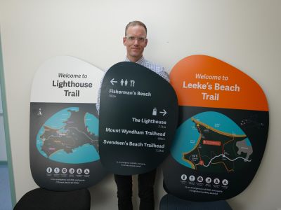 The project manager standing with the printed signage